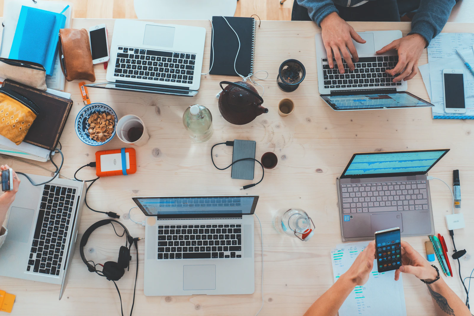 Team werkt aan laptops rond een tafel